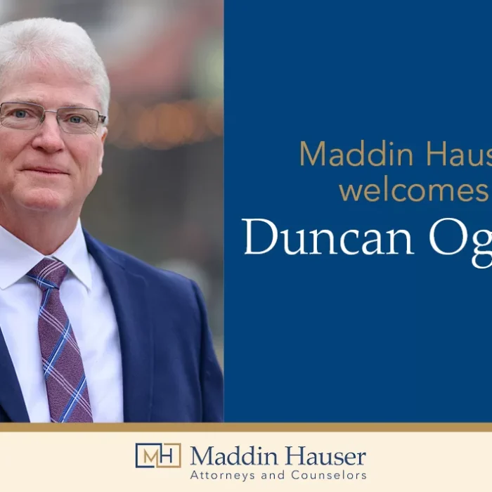 A man in a suit with the words Maddin Hauser welcomes Duncan Ogilvie